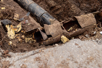 Excavated pit and old pipes. Broken pipe. Pipes reconstruction