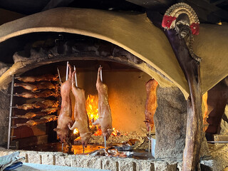 Preparing Various Porchetta on Charcoals, a tasty dish of roasted whole pig, which is seasoned with herbs. It is a typical food from the island of Sardinia, Italy © Gustavo Muñoz