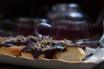 Classic chocolate eclair with custard cream and chopped walnuts on top