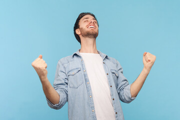 Man raises clenched fists, exclaims with excitement, rejoices sweet success, feels taste of...