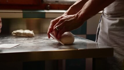 Chef preparing dough on stainless steel counter in kitchen