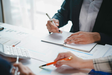 Business team working together, analyzing financial documents and taking notes during a productive meeting in the office