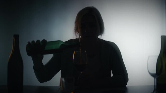 Unhappy drunk woman pouring wine in glass, feeling lonely and crying, breakup