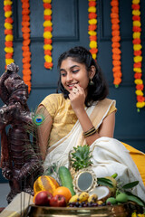 Kerala festival Vishu photo, Beautiful girl wearing traditional dress and arranging Vishu Kani