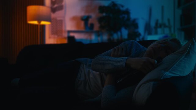 Intoxicated woman sleeping on couch hugging empty alcohol bottle, bad habits