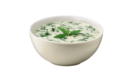 Delicious creamy spinach soup garnished with fresh basil leaves in a white bowl