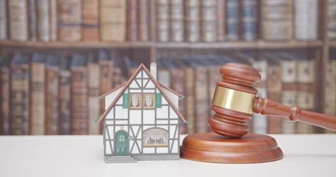 Legal issues, property, real estate law and transactions. A residential house beside the judge's gavel. The intersection of law and real estate in various aspect e.g property rights, contract, etc