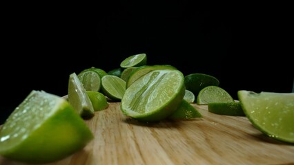 Close-up, a vibrant slice of fresh lime rests upon a rustic wooden cutting board, exuding freshness and vitality. The translucent membranes of the green lime slice placed on cutting board. Comestible.