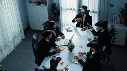 Top view of manager working on laptop and sending data analysis to business people by using VR glass headset while diverse team moving gesture while working together to planning idea. Directorate.