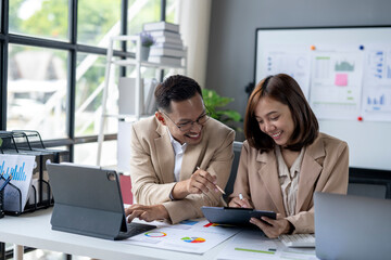 Two people are sitting at a desk looking at a presentation
