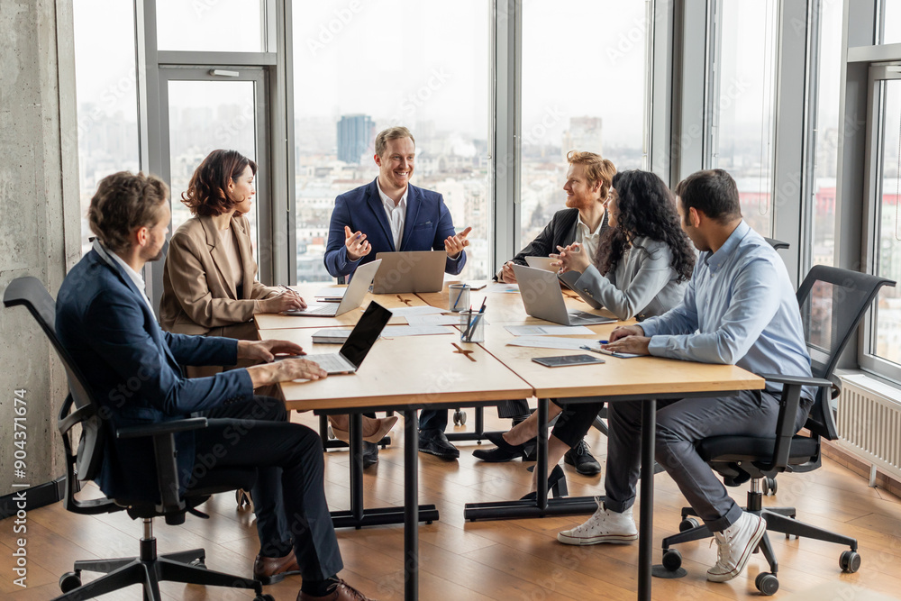 Leinwandbilder a group of five professionals are seated around a large, rectangular table in a modern office. they 