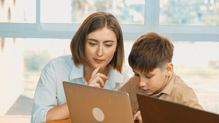 Smart boy coding program or learning prompt at STEM technology class. Caucasian student study about...