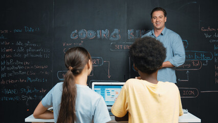 Caucasian teacher answering student question while holding tablet. Caucasian girl pointing at...
