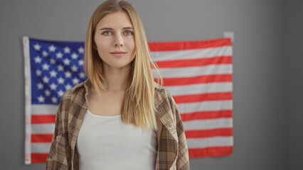A young caucasian woman with blonde hair posing indoors in front of an american flag, embodying...