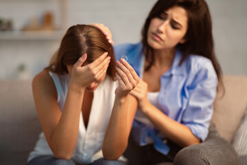 Divorce Concept. Friend Comforting Desperate Girl After Breakup With Ex-Husband Holding Ring...