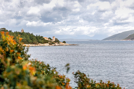 Cruise to Fiskardo Kefalonia Greek island, Ionian Sea near Preveza. Summer vacation. Cloudy sky and red flowers on the foreground