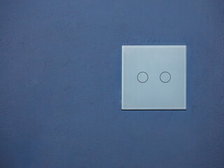touch light switch on minimalistic blue wall