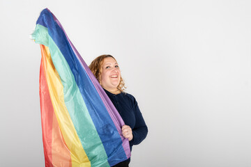 Studio shot of woman holding LGBT rainbow flag