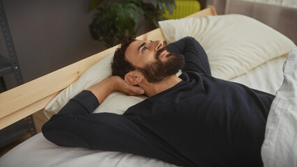 Handsome bearded man resting peacefully in a modern bedroom, evoking feelings of relaxation and comfort.