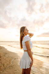 Happy tourist looking at amazing sunset. Seascape at sunset with beautiful sky. Travel, weekend, relax and lifestyle concept.