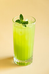 Mint lemonade with a sprig of mint on a beige background