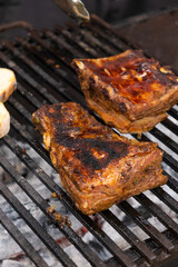 Marinated pork ribs are cooked on the coals of barbecue