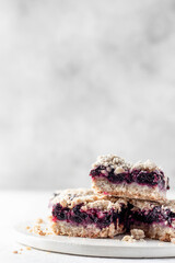 Baked oatmeal bars or crumble squares with fresh blueberry on white background with text space. Menu, recipe