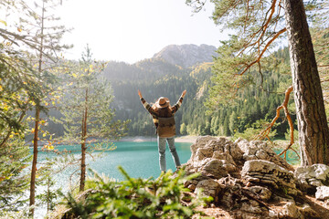Active woman with backpack enjoying wild nature. Mountains, Lake, green forests. Positive emotions...