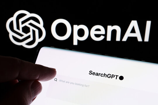 Hand pointing at SearchGPT page seen on the smartphone and official OpenAI company logo on background. New AI search tool. Stafford, United Kingdom, July 31, 2024