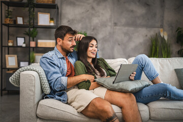 Obraz premium Girlfriend watch movie on tablet with her sleepy boyfriend