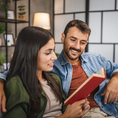 relax couple boyfriend and girlfriend sit on sofa and read a book