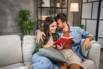relax couple boyfriend and girlfriend sit on sofa and read a book