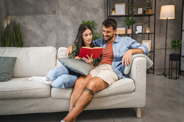 relax couple boyfriend and girlfriend sit on sofa and read a book