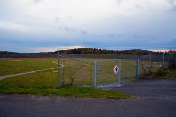 Fenced Open Field Under Cloudy Sky