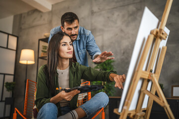 girlfriend learn from her boyfriend how to do paint and hold brush