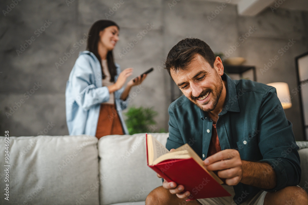 Wall mural adult focus and concentrated man read a book on sofa