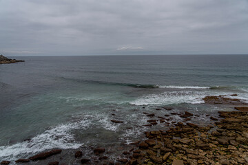 Majestic coastal cliffs with layered rock formations and lush greenery overlooking the sea in Cantabria, Spain. Perfect for landscape, travel, and nature themes.