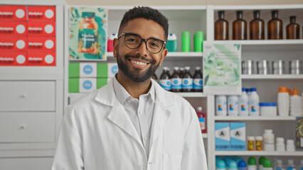 Smiling young man pharmacist standing confidently in a modern drugstore