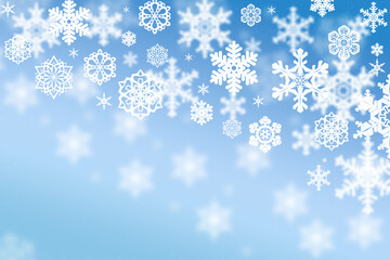 Fototapeta premium A stunning winter wonderland unfolds as delicate white snowflakes gracefully drift down against a backdrop of soft blue sky.
