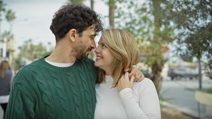 Intimate couple embracing lovingly on a city street, conveying a deep connection between the man and woman against an urban backdrop.