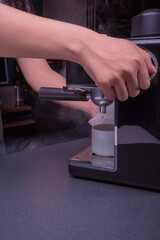 Woman Barista operates a machine to prepare delicious coffee, using the coffee machine