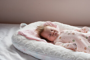 Caucasian Newborn baby sleeping in a baby lounger. Baby nest. Baby sleep concept