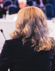 Group of women in business suits at round table, board meeting, roundtable talking and discussing...