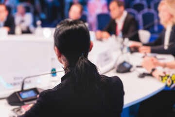 Group of women in business suits at round table, board meeting, roundtable talking and discussing at conference, female politicians and entrepreneurs, businesswomen dialog on forum, panel discussion