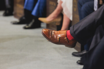 Speakers shoes legs at the business conference event, audience on forum summit, plenary session...
