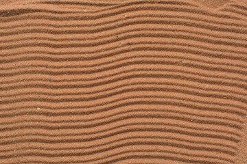 Lines drawn in brown sand background, beautiful sand texture, overhead view of chocolate brown sand, zen pattern drawn in the sand, Top view of fine grain texture