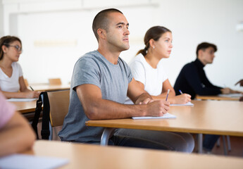 Caucasian man with adult students studying in university
