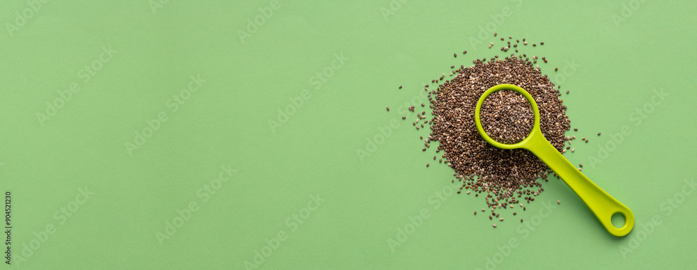 Poster organic fresh chia seeds in spoon - salvia hispanica. green color background