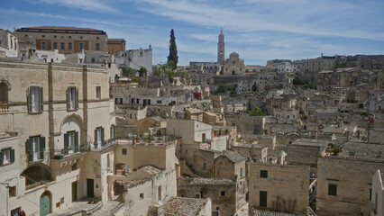 Historic rooftops and stone buildings under a bright sky in matera, basilicata, italy, showcasing ancient architecture and scenic views.
