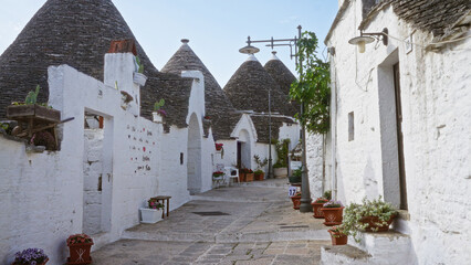 Alberobello town in puglia, italy, features iconic trulli houses with white stone walls and conical...